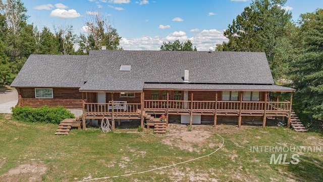 back of property featuring a shingled roof, stairway, a yard, and a deck