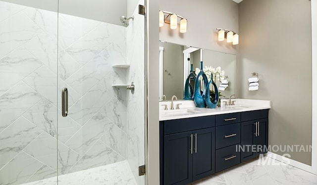 bathroom with marble finish floor, a shower stall, and a sink