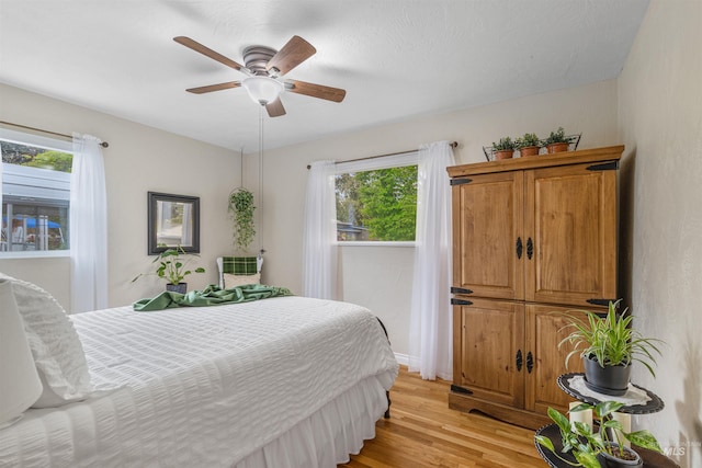 3233 8th St, Lewiston, ID 83501 - bedroom with light wood-style floors, multiple windows, baseboards, and a ceiling fan