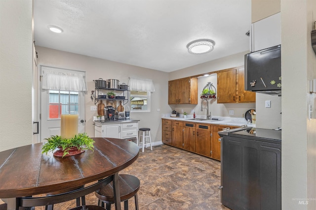 3233 8th St, Lewiston, ID 83501 - kitchen featuring brown cabinetry, light countertops, a sink, and baseboards