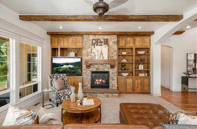 living room with beamed ceiling and a fireplace