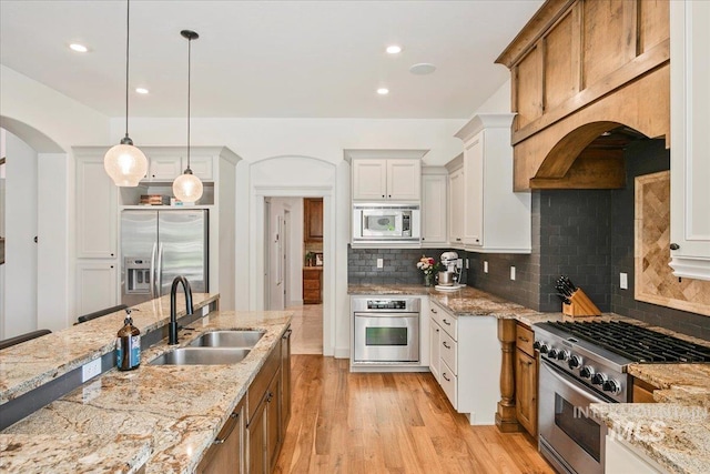 kitchen featuring sink, decorative light fixtures, white cabinets, and appliances with stainless steel finishes