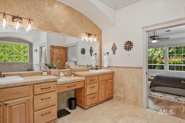 bathroom with tile walls, vanity, tile patterned flooring, and ornamental molding