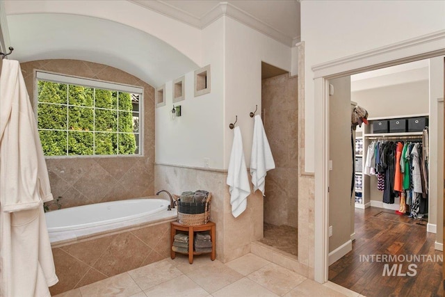 bathroom with tile patterned flooring, crown molding, and plus walk in shower