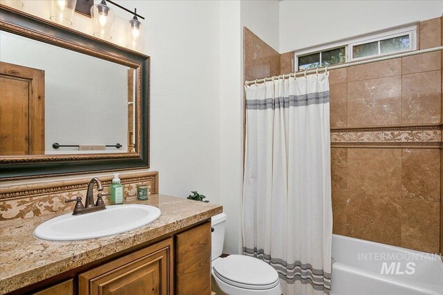 full bathroom featuring vanity, shower / bath combo, and toilet