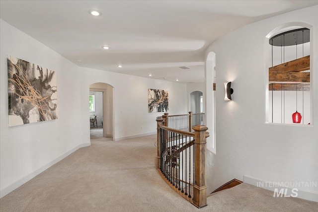 hallway featuring light colored carpet