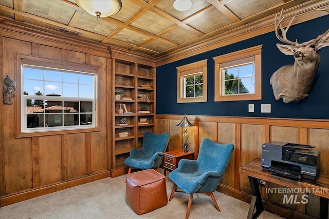 living area with coffered ceiling, ornamental molding, wooden walls, built in features, and light colored carpet