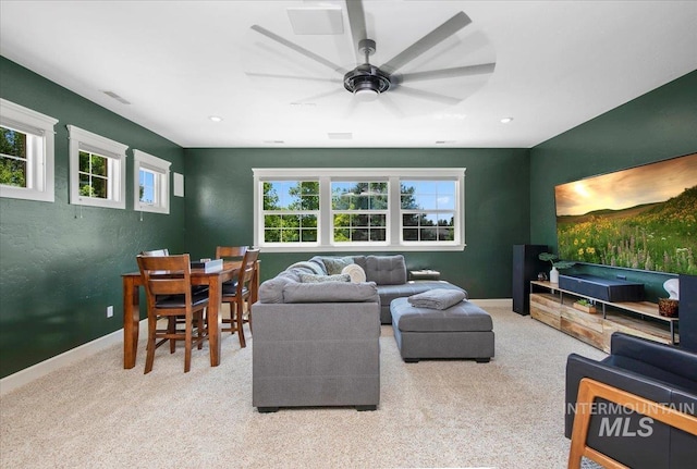 carpeted living room with ceiling fan and a wealth of natural light