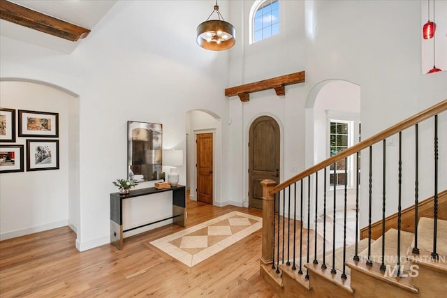 entrance foyer with a high ceiling and light wood-type flooring