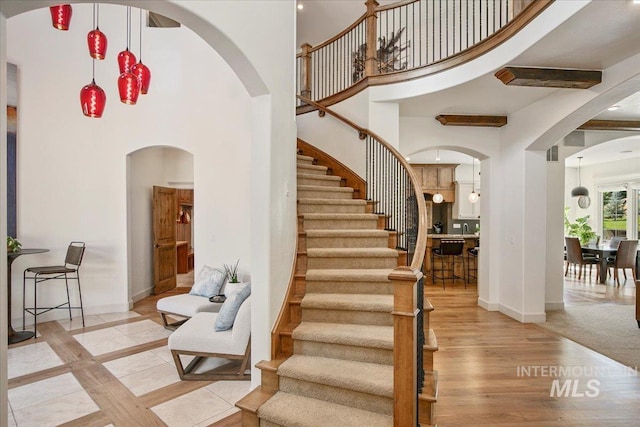 foyer entrance with a towering ceiling and light hardwood / wood-style flooring