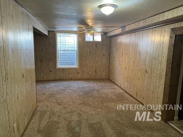 604 Monte Vis, Twin Falls, ID 83301 - basement featuring carpet flooring, ceiling fan, and wooden walls