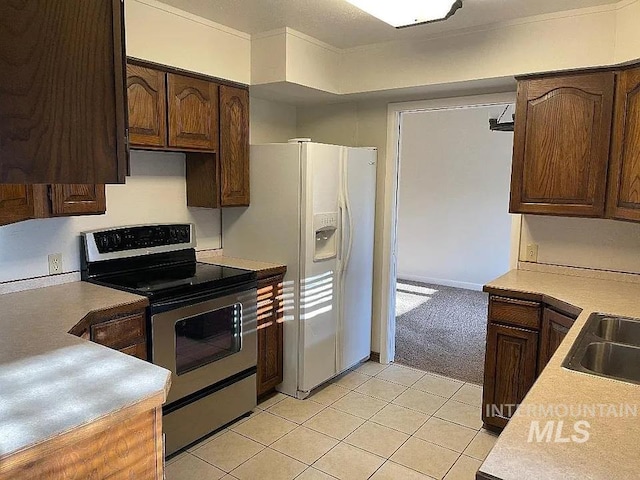 604 Monte Vis, Twin Falls, ID 83301 - kitchen featuring electric stove, white fridge with ice dispenser, light countertops, and light tile patterned floors