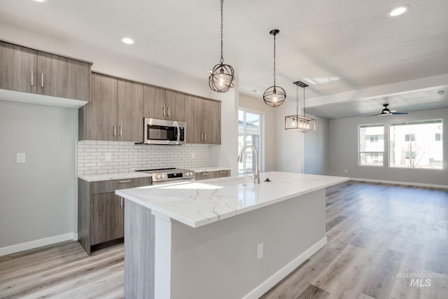 3542 W Littleton Dr, Meridian, ID 83642 - kitchen featuring appliances with stainless steel finishes, a sink, baseboards, modern cabinets, and backsplash