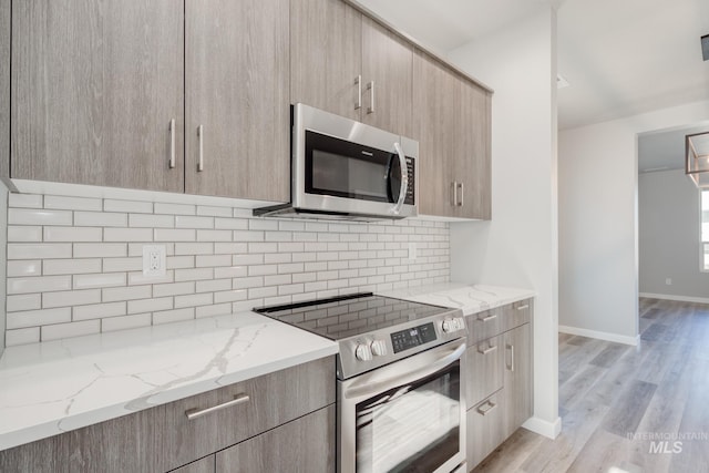 3542 W Littleton Dr, Meridian, ID 83642 - kitchen with stainless steel appliances, modern cabinets, light brown cabinetry, backsplash, and light stone counters