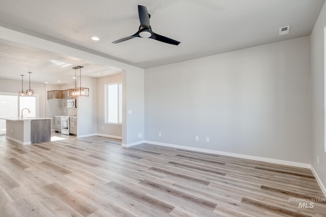 3542 W Littleton Dr, Meridian, ID 83642 - unfurnished living room with recessed lighting, healthy amount of natural light, a chandelier, baseboards, and a ceiling fan
