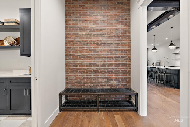 interior space with hardwood / wood-style flooring, vanity, and brick wall