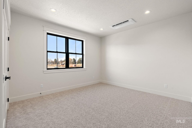 spare room with carpet flooring and a textured ceiling