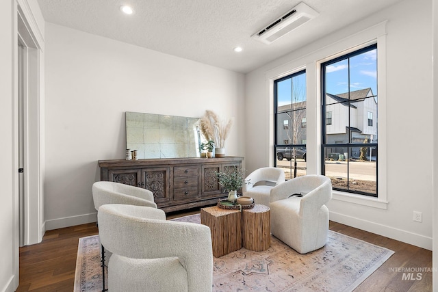 living area with hardwood / wood-style floors and a textured ceiling