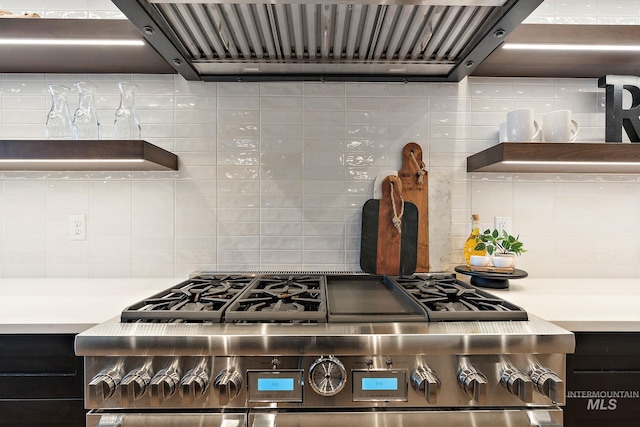 interior details with ventilation hood, decorative backsplash, and high end stove