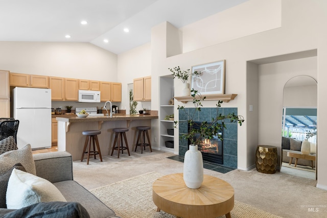 6460 S Lodgepole Pl, Boise, ID 83716 - living area featuring high vaulted ceiling, light carpet, recessed lighting, a tiled fireplace, and baseboards