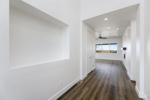 hall with visible vents, recessed lighting, dark wood-type flooring, and baseboards