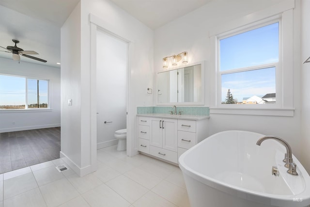 bathroom featuring plenty of natural light, toilet, vanity, and tile patterned flooring