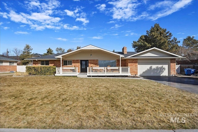 single story home featuring a front yard, fence, driveway, an attached garage, and brick siding