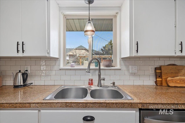 kitchen featuring a sink, hanging light fixtures, tile counters, white cabinetry, and tasteful backsplash