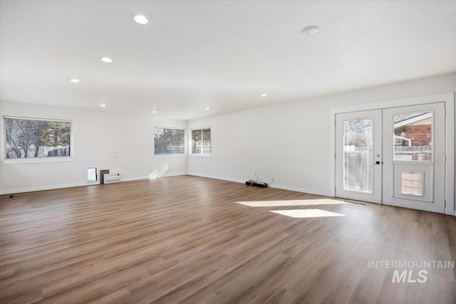 unfurnished living room with wood finished floors, recessed lighting, french doors, and baseboards