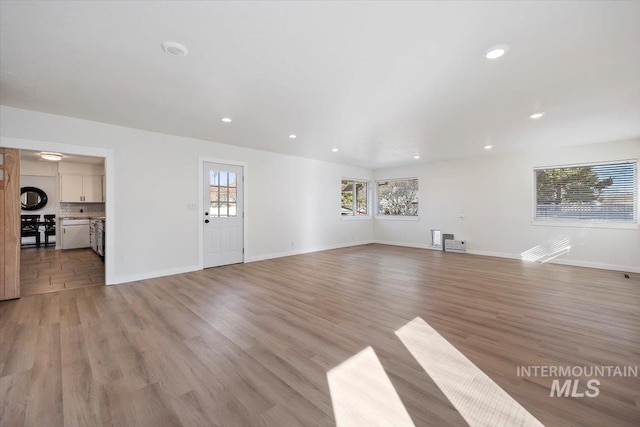 unfurnished living room featuring light wood-style flooring, recessed lighting, and a wealth of natural light