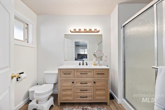 full bathroom with vanity, toilet, wood finished floors, and a shower stall