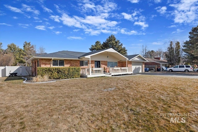 ranch-style home featuring brick siding, a front lawn, a garage, and fence