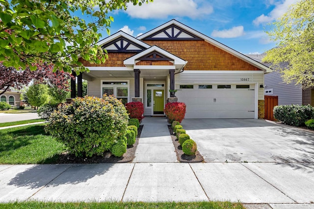 craftsman-style house featuring a garage, concrete driveway, a porch, and stone siding