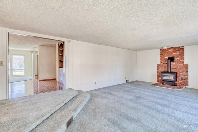 412 N Purdue St, Boise, ID 83706 - unfurnished living room with a wood stove, a textured ceiling, and carpet