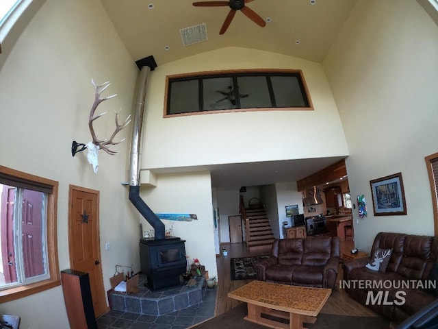 204 S 2nd St, Elk River, ID 83827 - living area with high vaulted ceiling, a wood stove, a ceiling fan, and stairs