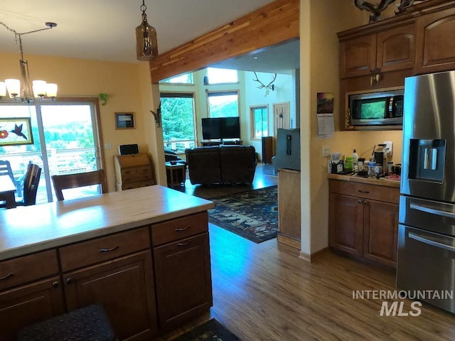 204 S 2nd St, Elk River, ID 83827 - kitchen with appliances with stainless steel finishes, a chandelier, wood finished floors, hanging light fixtures, and open floor plan