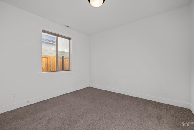 unfurnished room with dark colored carpet