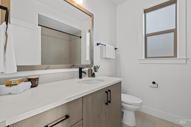 bathroom with toilet, vanity, and tile patterned floors