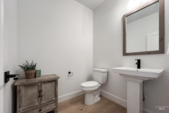 bathroom with sink, hardwood / wood-style floors, and toilet