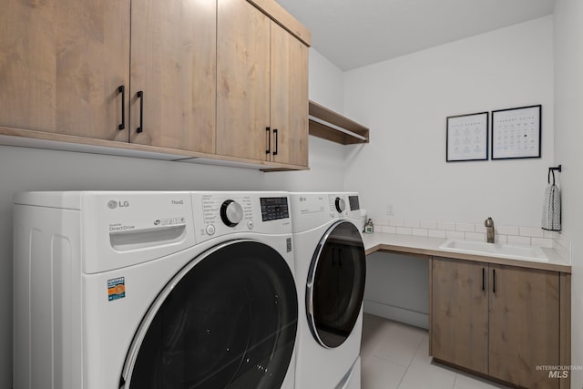 laundry area with independent washer and dryer, cabinets, light tile patterned flooring, and sink