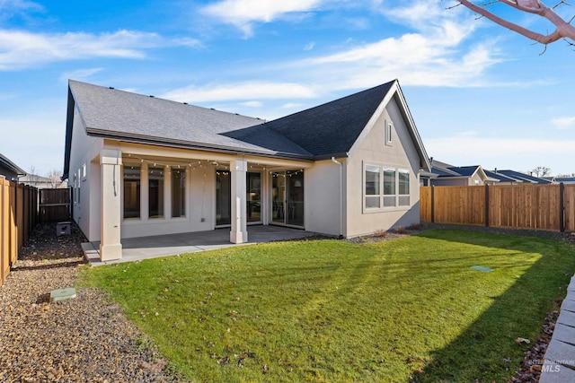 rear view of property featuring a lawn and a patio area