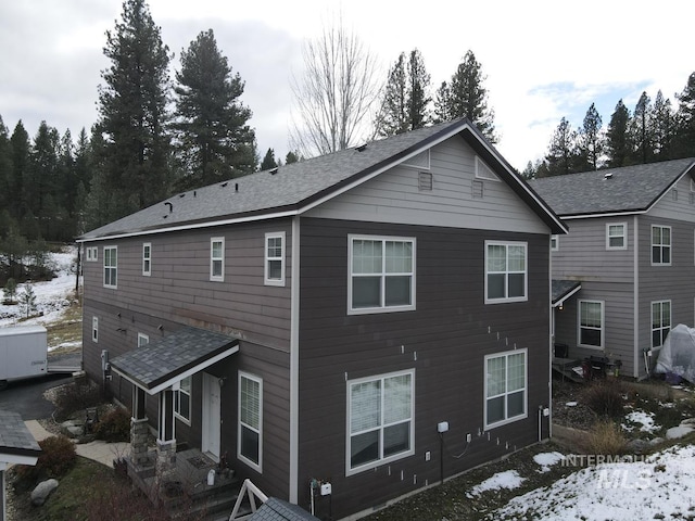 view of snow covered back of property