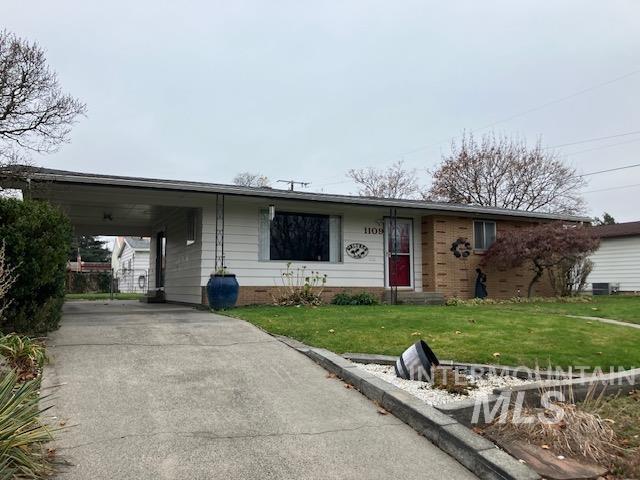 ranch-style home with a front yard and a carport