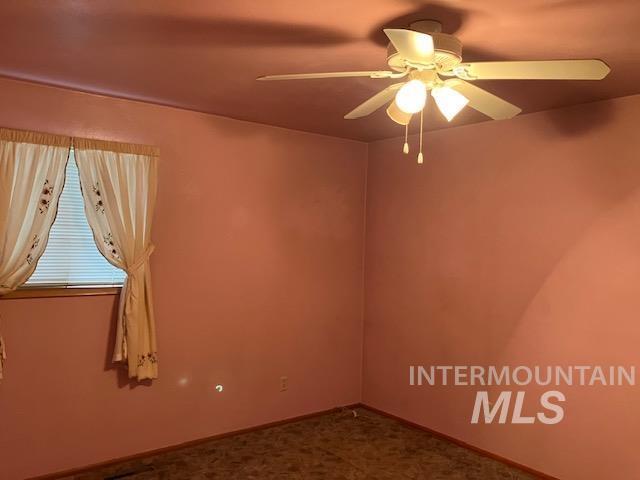 empty room with ceiling fan and carpet