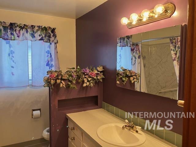 bathroom featuring a shower with shower curtain, vanity, and toilet