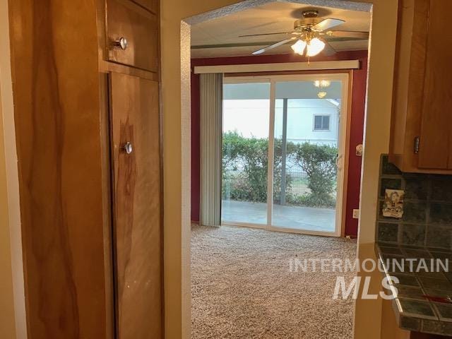 doorway with carpet and ceiling fan