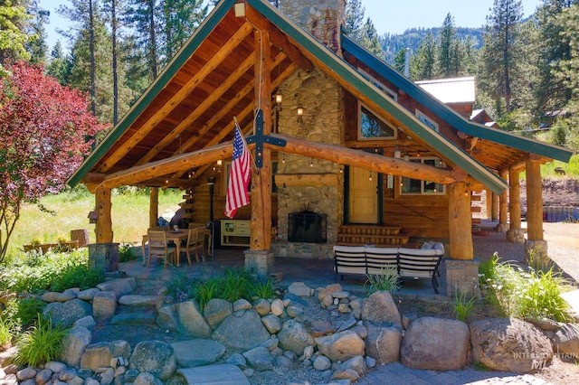 exterior space with a chimney, an outdoor hangout area, log exterior, and a patio