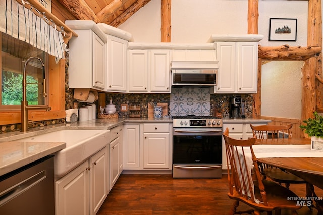 kitchen featuring tasteful backsplash, vaulted ceiling, stainless steel appliances, white cabinetry, and a sink