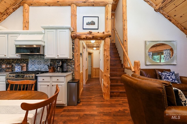 kitchen with dark wood-style floors, backsplash, appliances with stainless steel finishes, white cabinetry, and vaulted ceiling