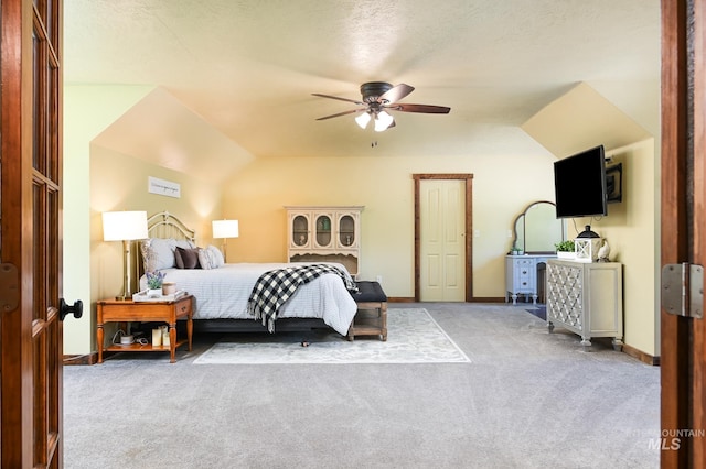 carpeted bedroom with vaulted ceiling, a textured ceiling, a ceiling fan, and baseboards